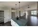 A large kitchen area with a central island and view into the main living space at 87 Tee Dr, Selma, NC 27576