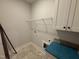 Laundry room features a utility sink, a wire rack for storage, and white cabinetry at 87 Tee Dr, Selma, NC 27576