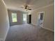 Large main bedroom with neutral carpet, a ceiling fan, windows with natural light, and a view into the ensuite bathroom at 87 Tee Dr, Selma, NC 27576