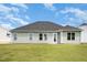 Back exterior view of the house showing the siding, windows, lawn and access to the backyard at 89 W Emily Gardens Dr, Selma, NC 27576
