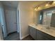 Well-lit bathroom with double sinks, gray cabinetry, a large mirror, and a shower-tub combination at 89 W Emily Gardens Dr, Selma, NC 27576