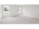 A bright bedroom with two windows allowing natural light and neutral-colored carpeting at 89 W Emily Gardens Dr, Selma, NC 27576