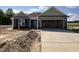 New home featuring a welcoming entrance, an attached two-car garage and a partially landscaped yard at 89 W Emily Gardens Dr, Selma, NC 27576
