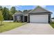 Charming single-story home boasts a well-manicured lawn and attached two-car garage at 89 W Emily Gardens Dr, Selma, NC 27576