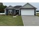 Charming single-story home featuring a two-car garage, well-manicured lawn, and appealing curb appeal at 89 W Emily Gardens Dr, Selma, NC 27576