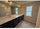 Bathroom featuring a double sink vanity with a large mirror, modern fixtures, and wood-look flooring at 9 W Emily Gardens Dr, Selma, NC 27576