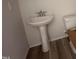 Pedestal sink and modern toilet in a half bathroom with wood-look floors and neutral paint at 9 W Emily Gardens Dr, Selma, NC 27576