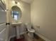 Cozy half bathroom with a pedestal sink, round mirror, and standard toilet at 9 W Emily Gardens Dr, Selma, NC 27576