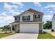Charming two-story home showcasing a two-car garage, neutral siding, and a well-manicured front lawn at 9 W Emily Gardens Dr, Selma, NC 27576