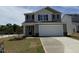 Charming two-story home featuring a two-car garage and well-manicured lawn on a sunny day at 9 W Emily Gardens Dr, Selma, NC 27576