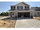 Two-story home with a large garage and neutral colored siding and stone accents at the garage entry at 9 W Emily Gardens Dr, Selma, NC 27576