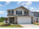 Charming two-story home showcasing a two-car garage, neutral siding, and a well-manicured front lawn at 9 W Emily Gardens Dr, Selma, NC 27576