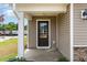 Inviting front porch featuring a dark front door, neutral siding, and stone accents at 9 W Emily Gardens Dr, Selma, NC 27576