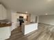 Well-lit kitchen with white cabinets, granite countertops, stainless steel appliances, and wood-look flooring at 9 W Emily Gardens Dr, Selma, NC 27576