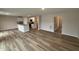 Open-concept kitchen and living area featuring white cabinets, wood-look flooring, and modern appliances at 9 W Emily Gardens Dr, Selma, NC 27576
