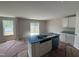Bright kitchen with a central island featuring a sink, white cabinets, and stainless steel dishwasher at 9 W Emily Gardens Dr, Selma, NC 27576