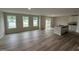 Open concept living area featuring wood-look flooring, bright windows, and a kitchen island with gray countertops at 9 W Emily Gardens Dr, Selma, NC 27576