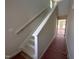 A newly constructed staircase with white risers and stringers, and a wood handrail against a neutral wall at 9 W Emily Gardens Dr, Selma, NC 27576