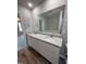 Bright bathroom featuring a large vanity with double sinks, granite countertops, and wood flooring at 91 Harvest Hills Ln, Dunn, NC 28334