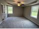 Spacious carpeted bedroom featuring a ceiling fan, trey ceiling and natural light from the double-hung windows at 91 Harvest Hills Ln, Dunn, NC 28334