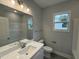 Bathroom featuring a modern vanity with sink, toilet, tub with shower, and natural light at 98 Laramie Ln, Selma, NC 27576