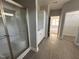 Bathroom with walk-in shower, white cabinets, tile flooring and view into bedroom at 98 Laramie Ln, Selma, NC 27576