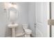 Stylish half bathroom with pedestal sink, soft blue walls, and modern fixtures at 98 Laramie Ln, Selma, NC 27576