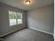Neutral bedroom with plush carpet, and a window overlooking a tree lined lot and fence at 98 Laramie Ln, Selma, NC 27576
