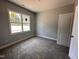 This is a bedroom with a large window that lets in plenty of natural light, and it has neutral-colored walls and carpet at 98 Laramie Ln, Selma, NC 27576