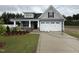 Charming two-story home with landscaped yard, attached garage, and welcoming front porch at 98 Laramie Ln, Selma, NC 27576