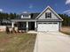 Charming new construction home with a two-car garage, covered porch, and well-manicured lawn at 98 Laramie Ln, Selma, NC 27576