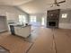Open concept living space with a stone fireplace, ceiling fan, and island with seating at 98 Laramie Ln, Selma, NC 27576
