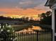 A backyard view showcasing a picturesque pond reflecting a vibrant sunset at 1005 Vesper Ct, Durham, NC 27703
