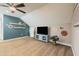 The bonus room has a TV, cute wall decor, and a ceiling fan that makes the space comfortable at 1005 Vesper Ct, Durham, NC 27703