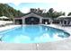 Community pool with umbrellas, lounge chairs, and poolhouse at 1005 Vesper Ct, Durham, NC 27703