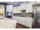 Modern kitchen with stainless steel appliances, white cabinets, gray backsplash, and granite countertops at 1005 Vesper Ct, Durham, NC 27703