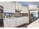 Modern kitchen with stainless steel appliances, white cabinets, gray backsplash, and granite countertops at 1005 Vesper Ct, Durham, NC 27703