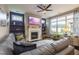 Inviting living room featuring a cozy fireplace, ceiling fan and large windows offering an abundance of natural light at 1005 Vesper Ct, Durham, NC 27703