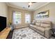 The bright living room includes a plush beige couch, large windows, and a unique rug that ties it all together at 1005 Vesper Ct, Durham, NC 27703