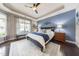 This primary bedroom boasts a tray ceiling, a plush rug, and large windows that provide tons of natural light at 1005 Vesper Ct, Durham, NC 27703