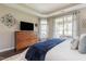 This primary bedroom features a dresser, large windows, and a TV for all of your entertainment needs at 1005 Vesper Ct, Durham, NC 27703