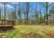 A spacious backyard featuring a wooden deck and a play set surrounded by lush greenery at 101 Elk River Ct. Ct, Mebane, NC 27302