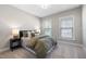 Comfortable bedroom with carpeted floors, a side table, and two bright, sunlit windows at 102 E Star Foal Ln, Wendell, NC 27591