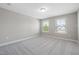 A bright, airy bedroom with carpeted flooring and two sunny windows at 102 E Star Foal Ln, Wendell, NC 27591
