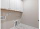 Functional laundry room with white cabinets, modern fixtures, and neutral paint creating a clean space at 102 E Star Foal Ln, Wendell, NC 27591