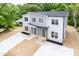 Aerial view of a gray duplex with modern design, set among mature trees and manicured landscaping at 1047 |1049 E Harnett St, Dunn, NC 28334
