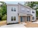 Two-story gray duplex with new landscaping, gray facade, covered entry with wood posts, and blue front doors at 1047 |1049 E Harnett St, Dunn, NC 28334