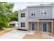Two-story gray duplex featuring newly installed landscaping, covered entry, and inviting blue doors at 1047 |1049 E Harnett St, Dunn, NC 28334