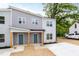 Charming gray two-story duplex with blue doors and fresh landscaping in a serene, wooded setting at 1047 |1049 E Harnett St, Dunn, NC 28334