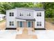 Modern two-story duplex features a gray facade, blue doors, and well-manicured landscaping at 1047 |1049 E Harnett St, Dunn, NC 28334